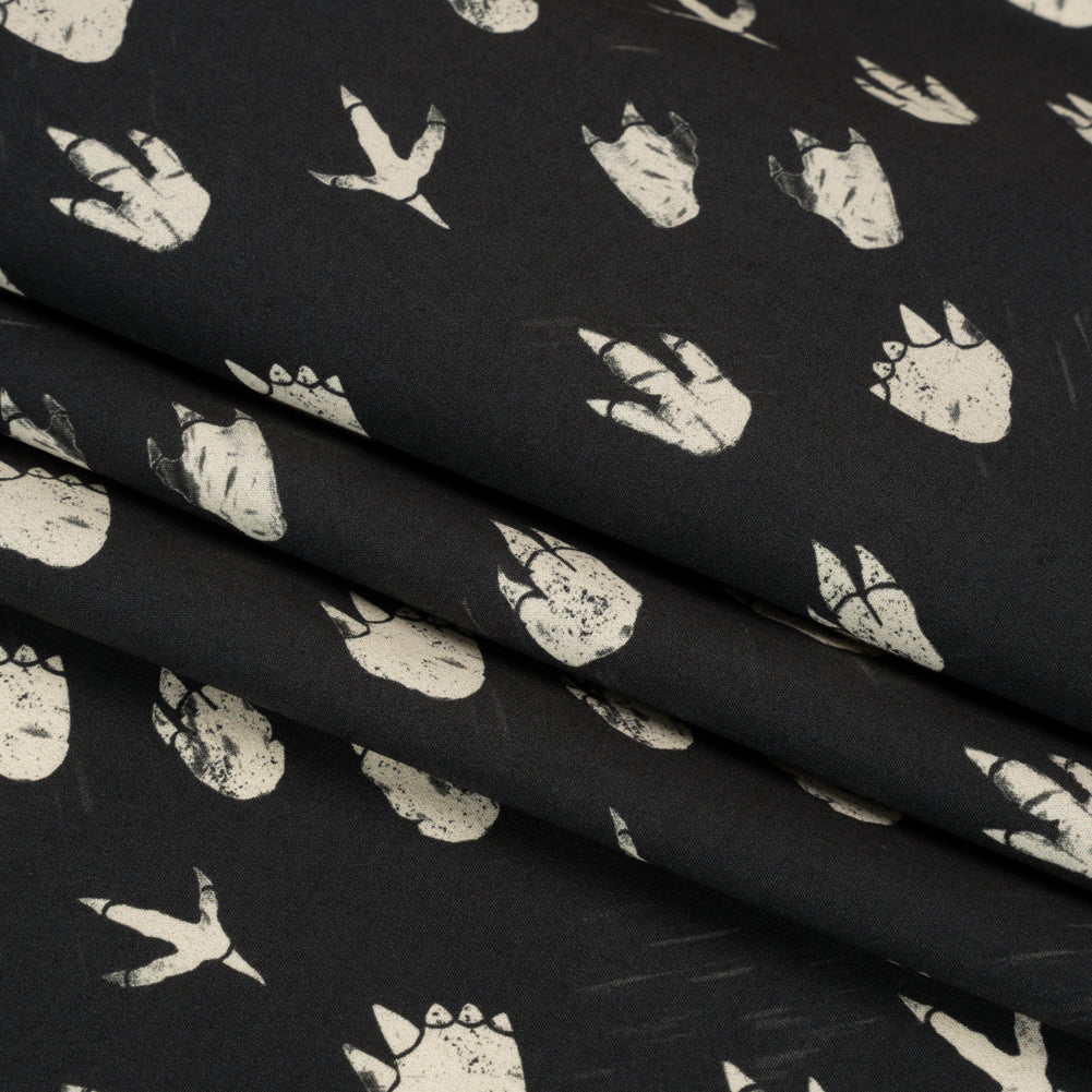 Stretch Cotton Poplin Print - Black Dinosaur Footprints - Mood Exclusive Jurassic Jubilee Folded Stretch Cotton Poplin Print - Black Dinosaur Footprints - Mood Exclusive Jurassic Jubilee Folded