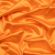 Premium Italian Orange Stretch Satin with Peach Backing | Mood Fabrics